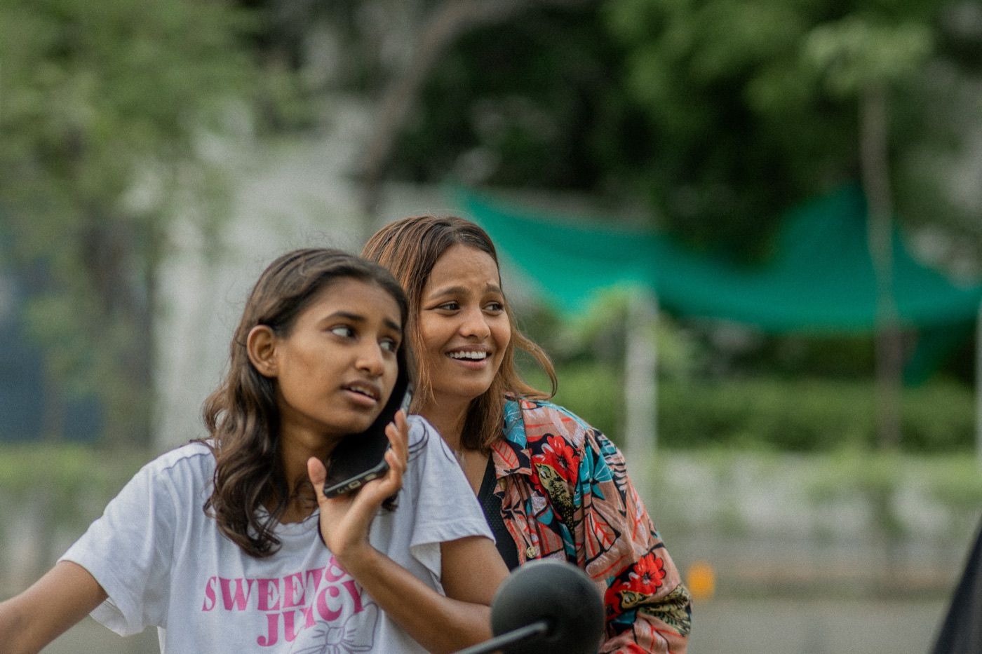 Two women sharing a candid, laughing moment at a Sunday morning gathering